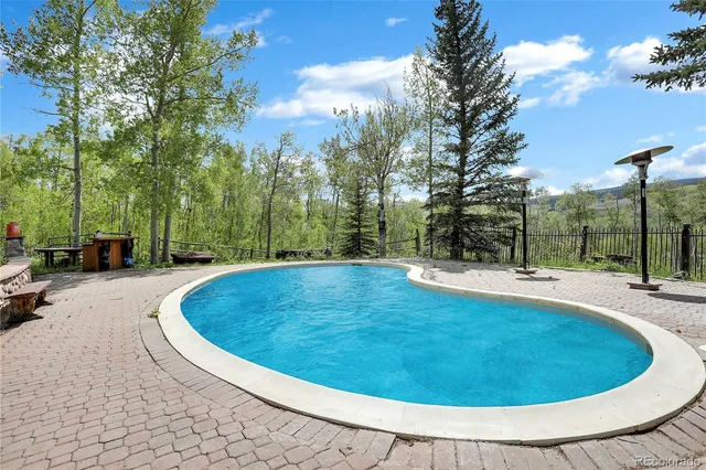 a swimming pool with outdoor seating and yard
