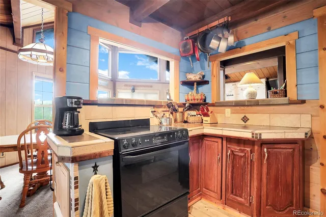 a kitchen with a stove a sink and a wooden cabinets