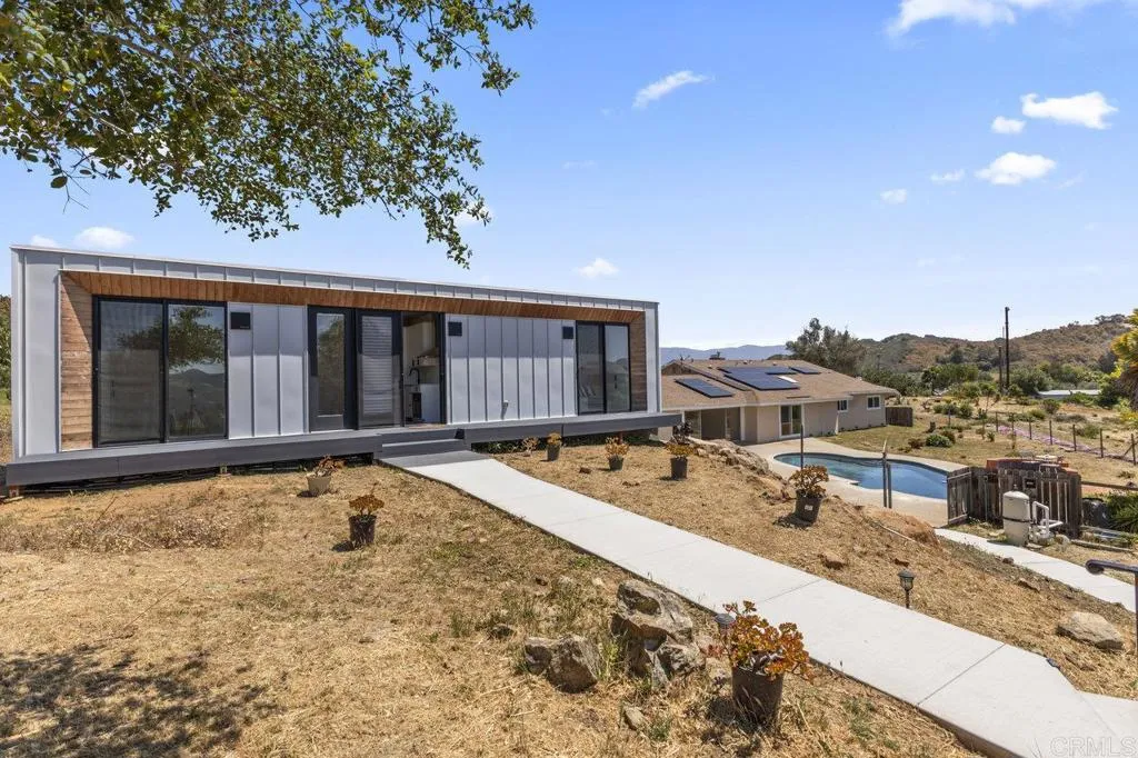 a view of a house with pool and sitting area