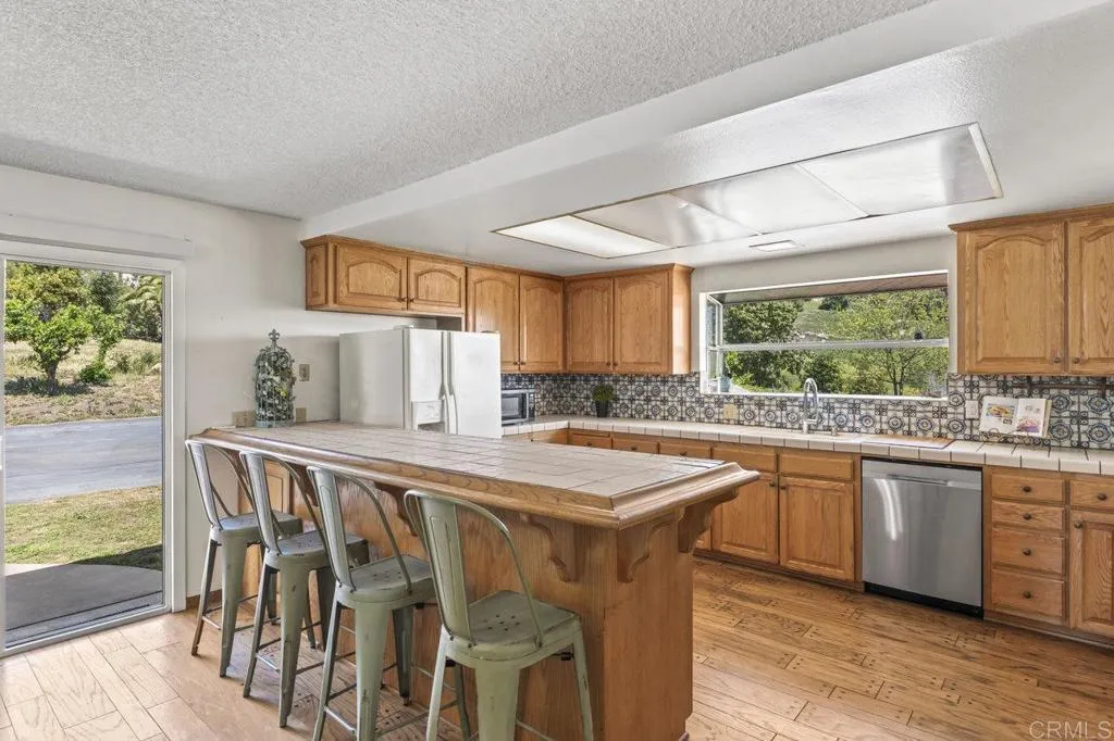 6825 Kellyn Lane Vista, CA 92084 - Photo 18 of 65 a kitchen with stainless steel appliances granite countertop a stove a sink and a microwave
