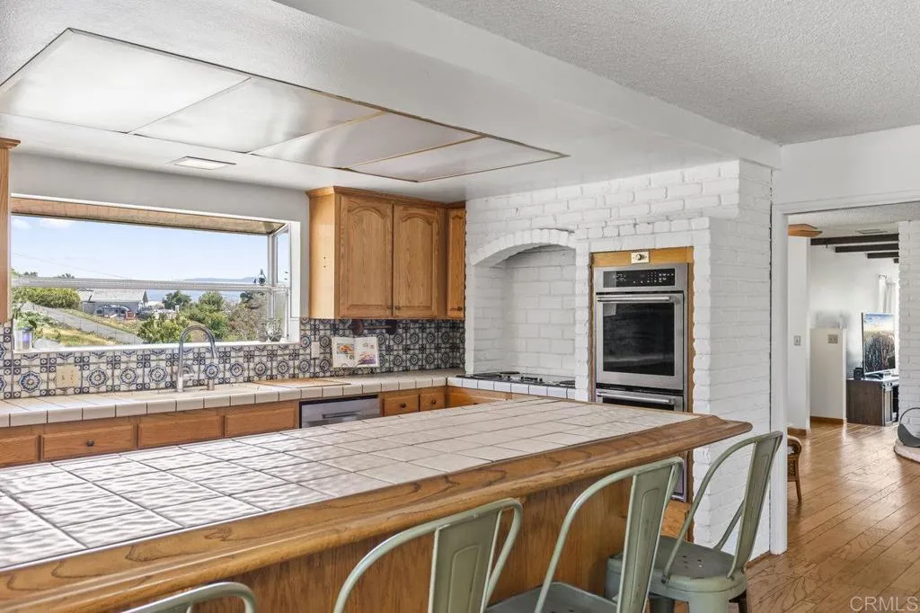 6825 Kellyn Lane Vista, CA 92084 - Photo 19 of 65 a living room with stainless steel appliances kitchen island granite countertop furniture and a large window