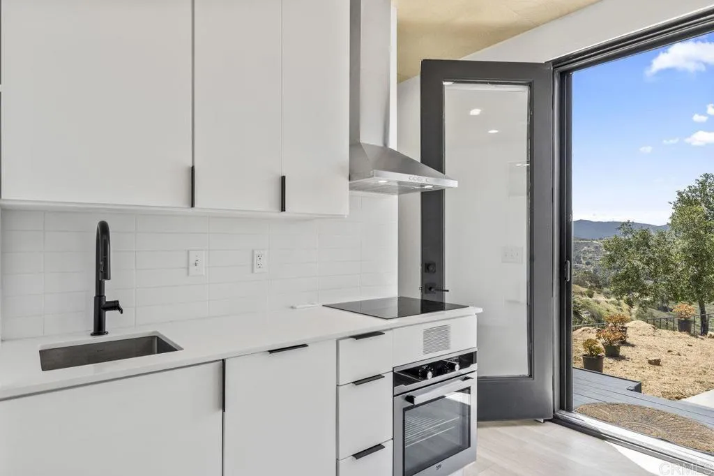 6825 Kellyn Lane Vista, CA 92084 - Photo 44 of 65 a kitchen with white cabinets and appliances