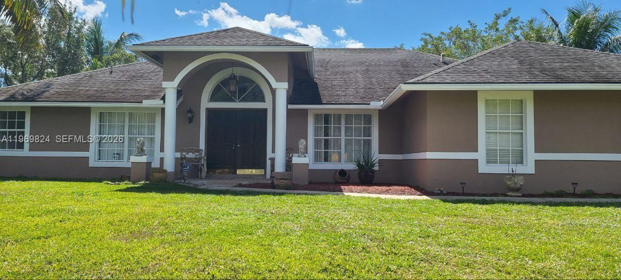 10920 Barn Road Lake Worth, FL 33449 - Photo 1 of 19 a front view of a house with garden