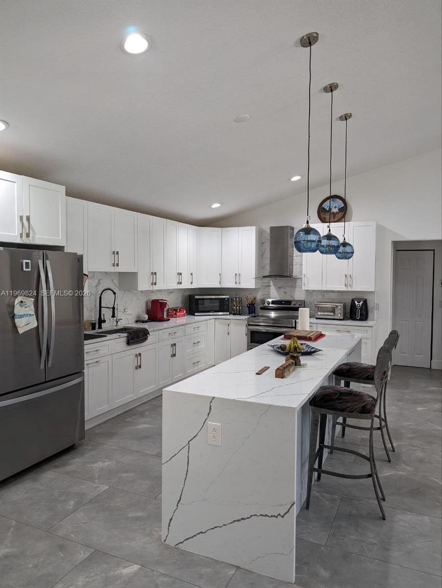 10920 Barn Road Lake Worth, FL 33449 - Photo 12 of 19 a kitchen with stainless steel appliances kitchen island a refrigerator sink and cabinets