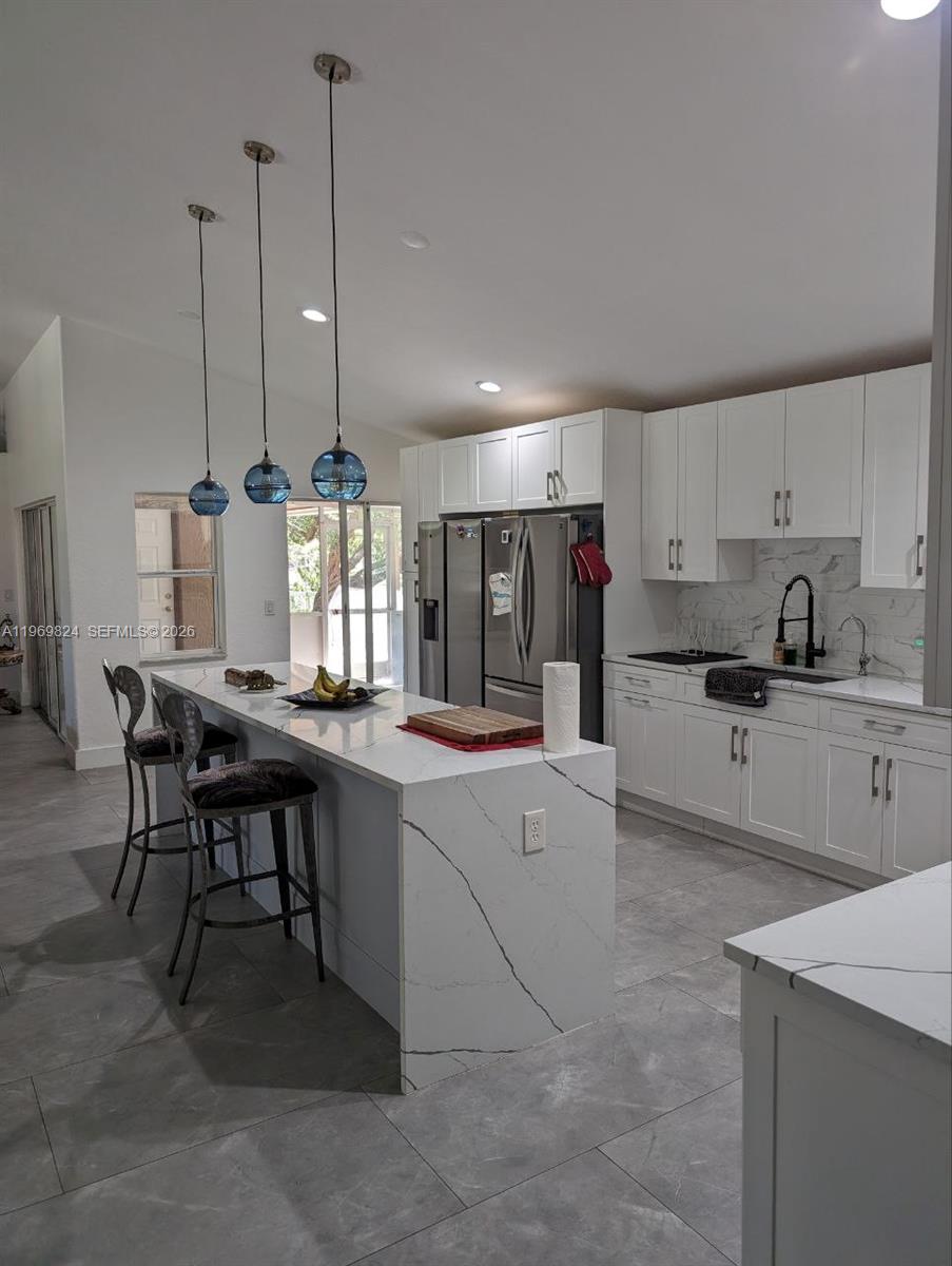 10920 Barn Road Lake Worth, FL 33449 - Photo 19 of 19 a kitchen with stainless steel appliances granite countertop a sink counter space and a refrigerator