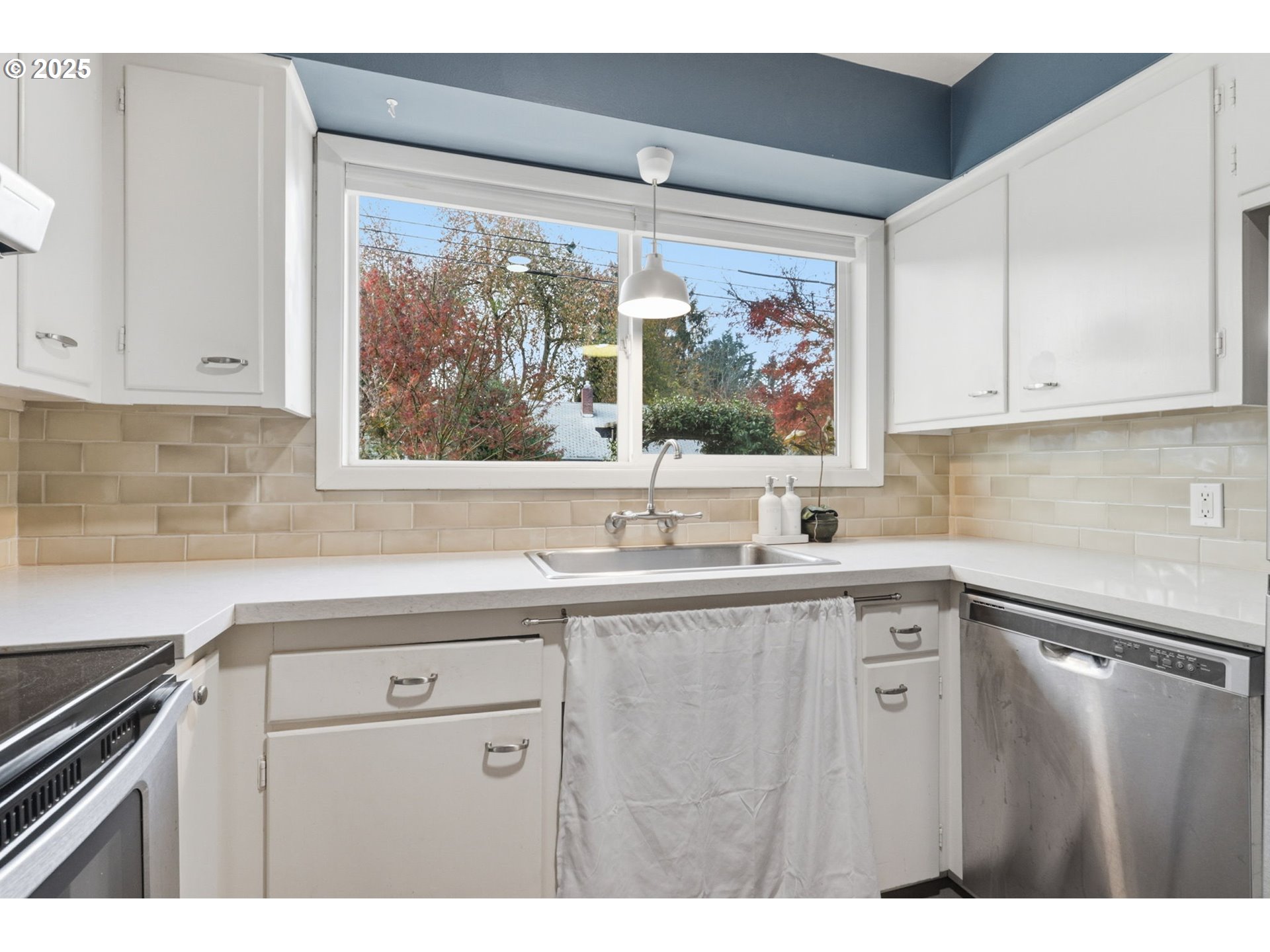 8502 North Hamlin Avenue Portland, OR 97217 - Photo 12 of 48 a kitchen with stainless steel appliances white cabinets a window and a sink