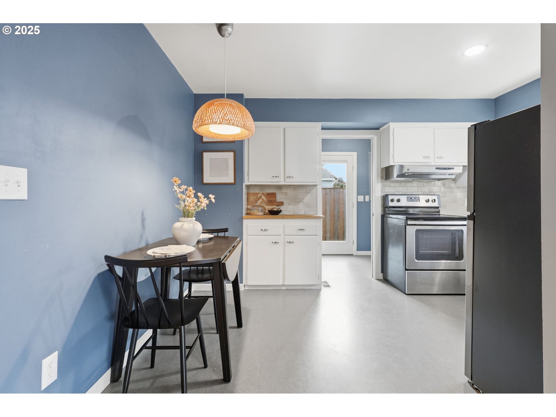 8502 North Hamlin Avenue Portland, OR 97217 - Photo 6 of 48 a kitchen with stainless steel appliances a dining table chairs and a refrigerator