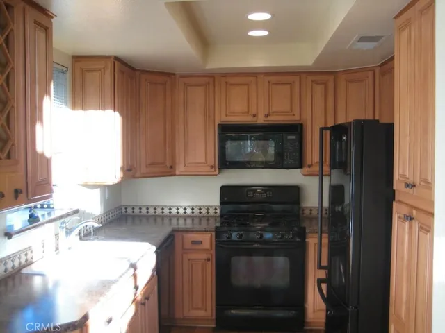 a kitchen with granite countertop a refrigerator stove and microwave