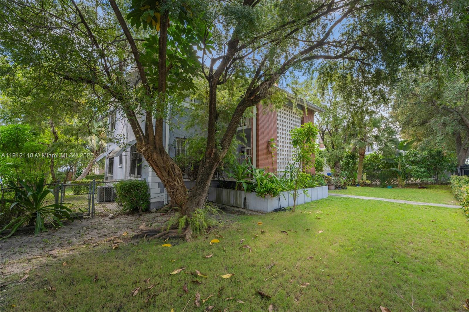 405 Southwest 11th Avenue Miami, FL 33130 - Photo 1 of 26 a view of backyard with table and chairs and large trees