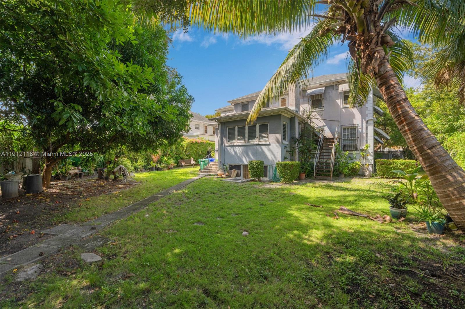 405 Southwest 11th Avenue Miami, FL 33130 - Photo 22 of 26 a view of a big house with a big yard and palm trees