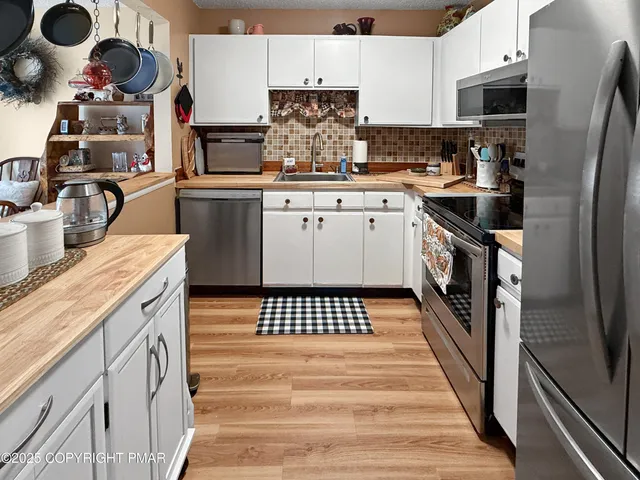 a kitchen with stainless steel appliances a stove and a microwave