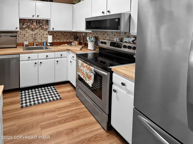a kitchen with stainless steel appliances a sink stove and cabinets