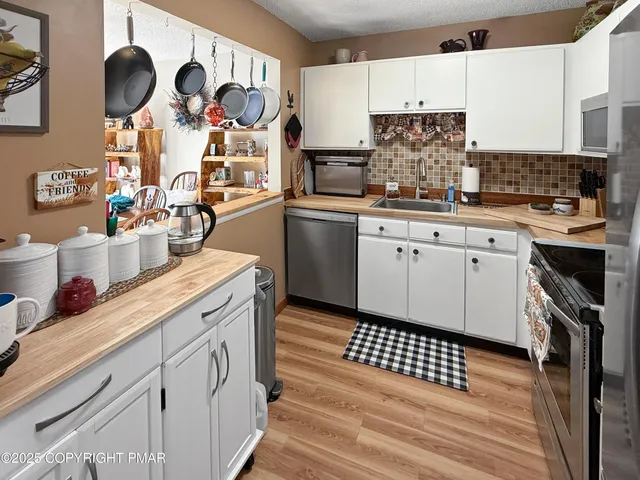 a kitchen with stainless steel appliances a stove a sink and a refrigerator