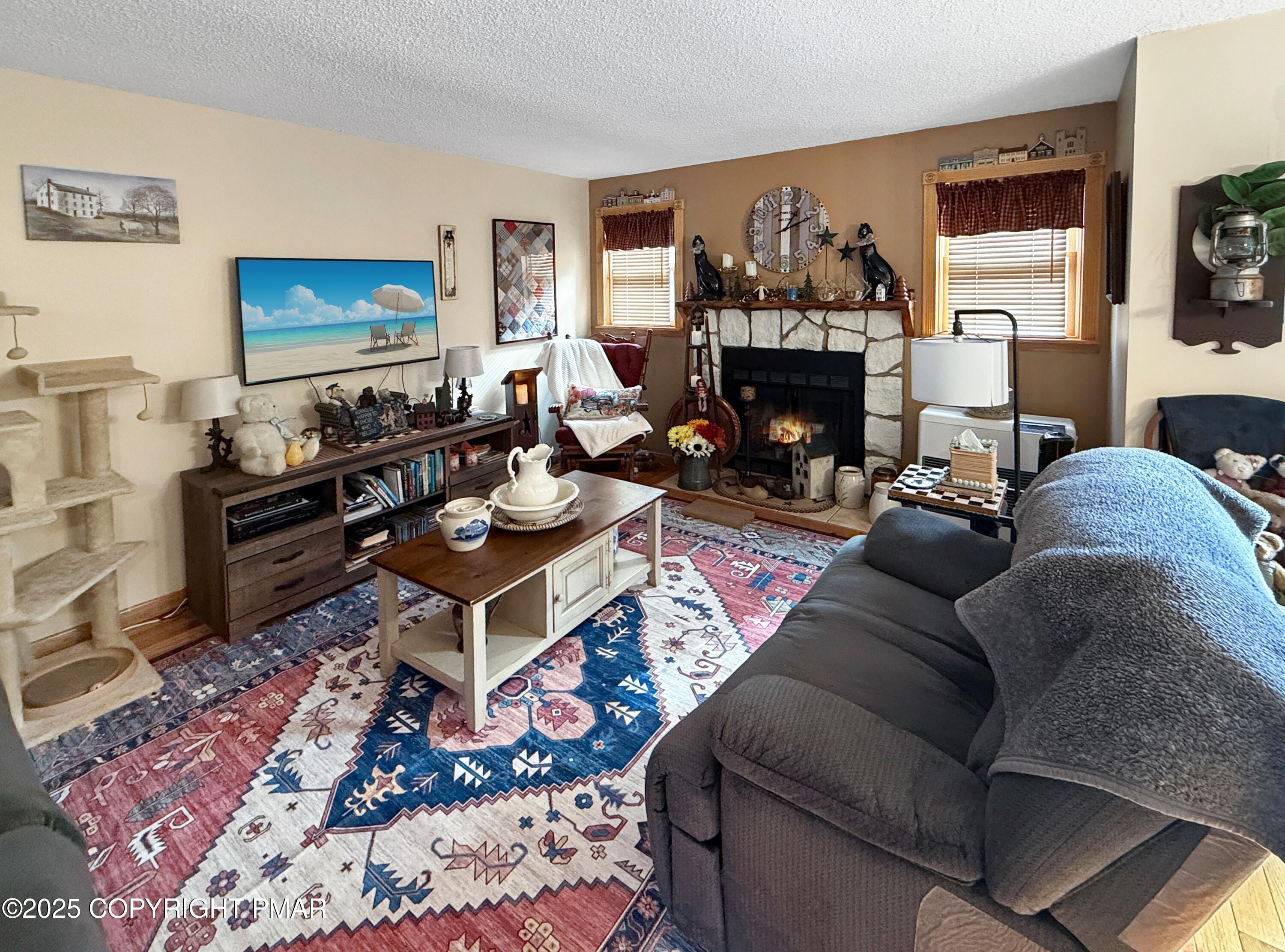 274 Nittany Court Mount Pocono, PA 18344 - Photo 10 of 28 a living room with furniture a rug and a fireplace