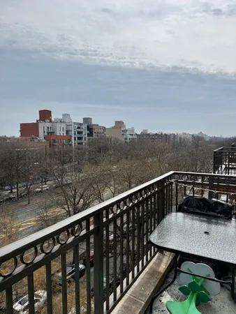 a view of a balcony with wooden floor and city view