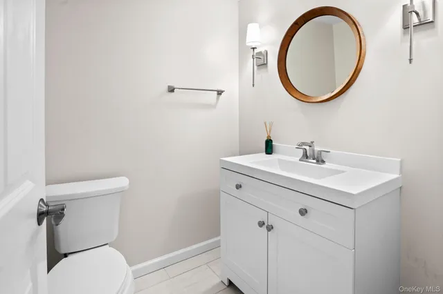 a bathroom with a toilet a sink and a mirror