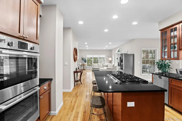 a kitchen with stainless steel appliances kitchen island granite countertop a stove a sink and a microwave