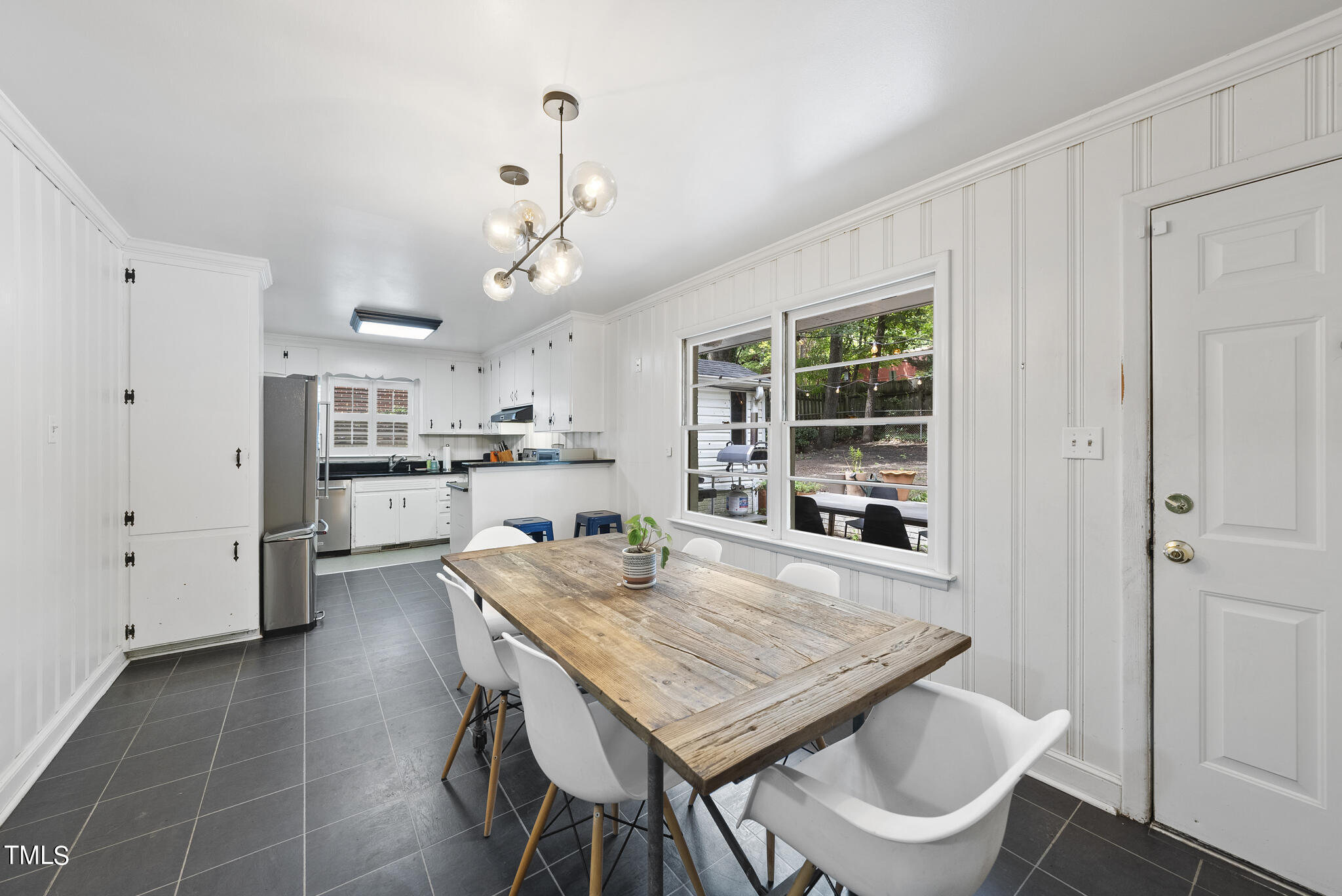 819 Beaver Dam Road Raleigh, NC 27607 - Photo 4 of 28 a kitchen with a table chairs refrigerator and cabinets