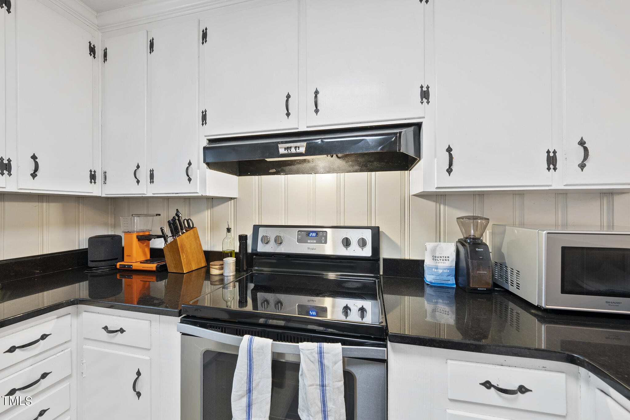 819 Beaver Dam Road Raleigh, NC 27607 - Photo 7 of 28 a kitchen with stainless steel appliances a stove a microwave and cabinets