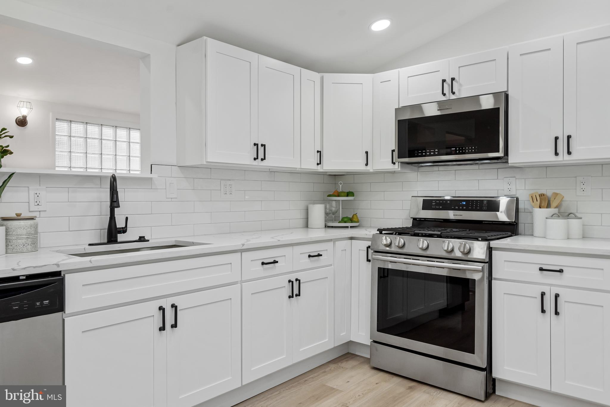 6136 Sinbad Place Columbia, MD 21045 - Photo 15 of 31 a kitchen with white cabinets and stainless steel appliances