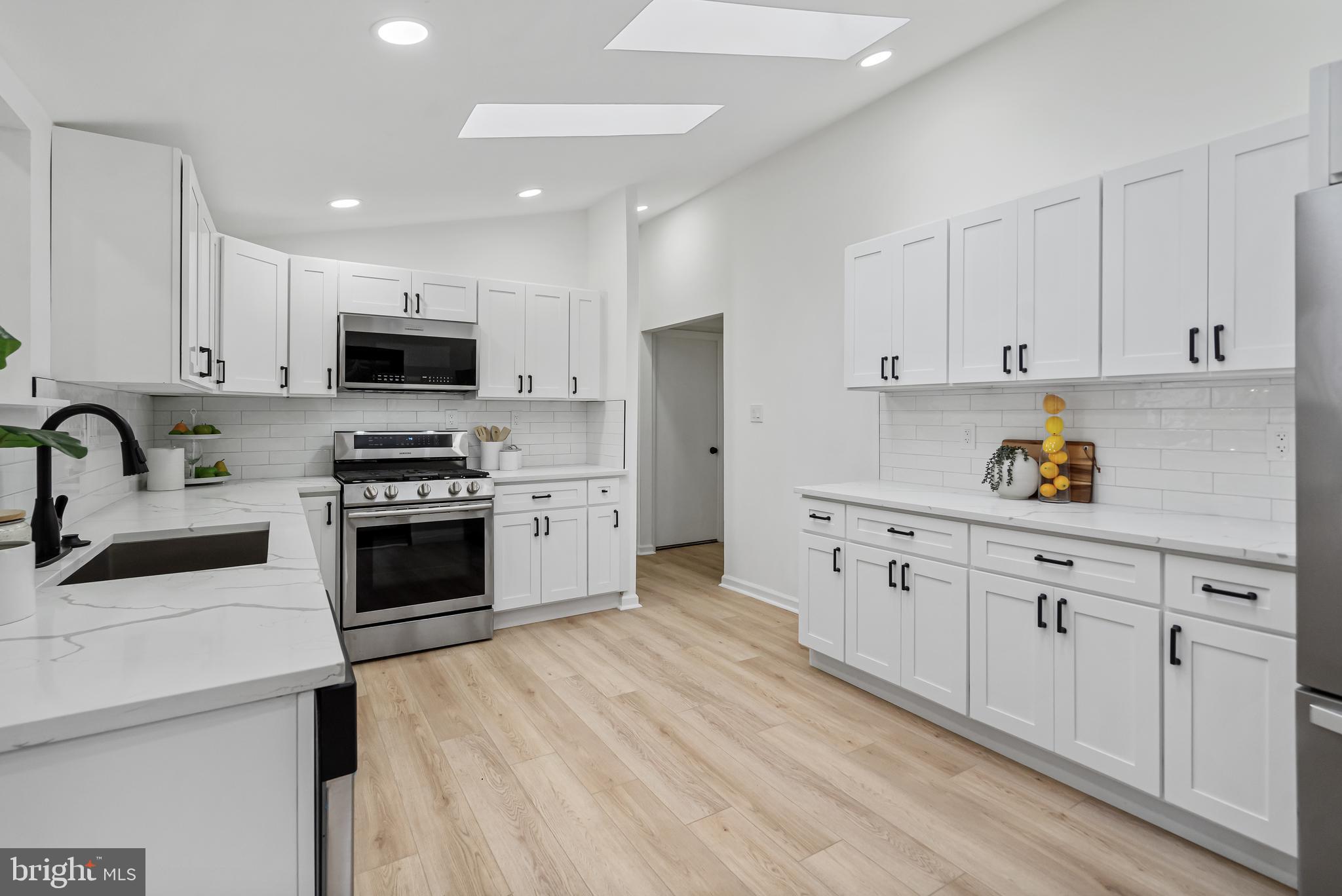 6136 Sinbad Place Columbia, MD 21045 - Photo 8 of 31 a kitchen with granite countertop white cabinets and stainless steel appliances