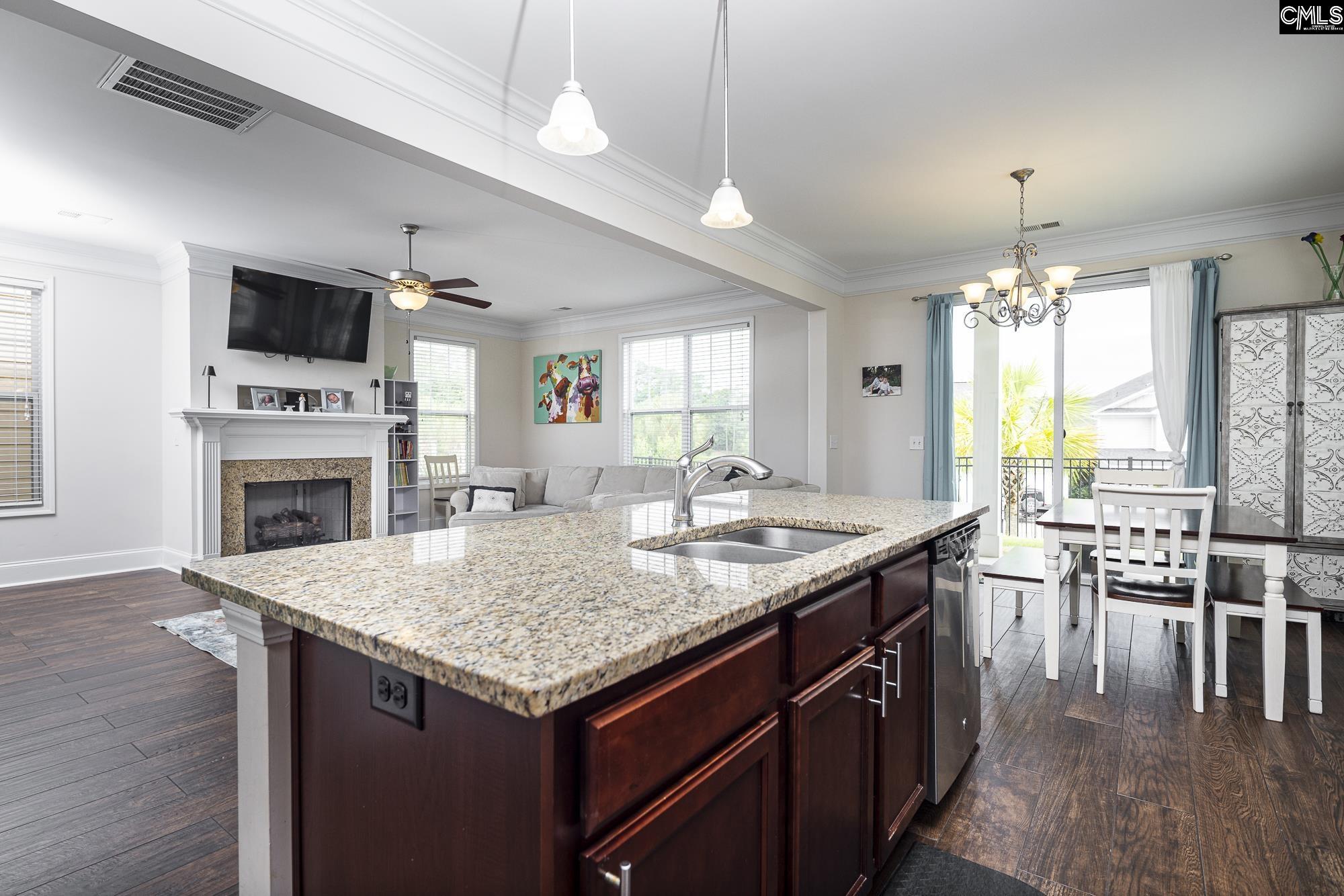 213 Sunset Point Drive Lexington, SC 29072 - Photo 13 of 35 a kitchen with a stove a center island a dining table and chairs with wooden floor