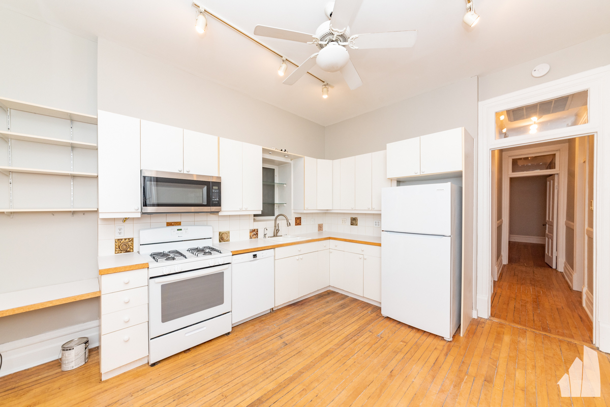 1420 West Irving Park Road, Unit 3 Chicago, IL 60613 - Photo 2 of 21 a kitchen with white cabinets and white appliances