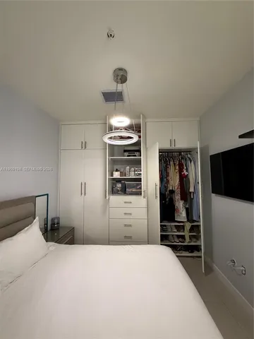 a bedroom with a bed and a refrigerator
