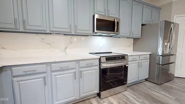 a metallic refrigerator freezer sitting in a kitchen