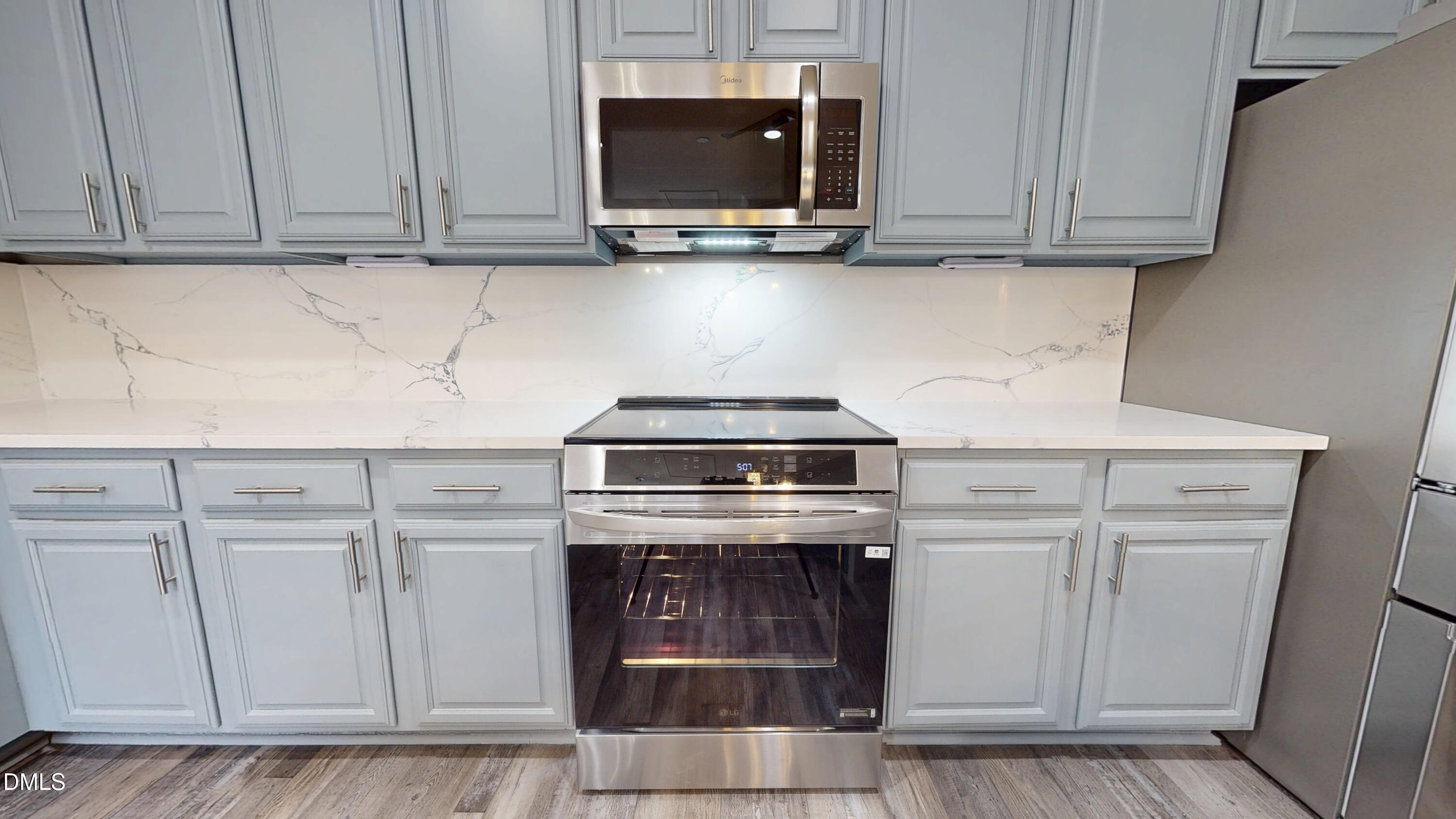 5708 Sea Fox Court Raleigh, NC 27616 - Photo 15 of 50 a kitchen with granite countertop white cabinets and stainless steel appliances