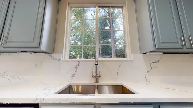 a kitchen with granite countertop white cabinets and stainless steel appliances