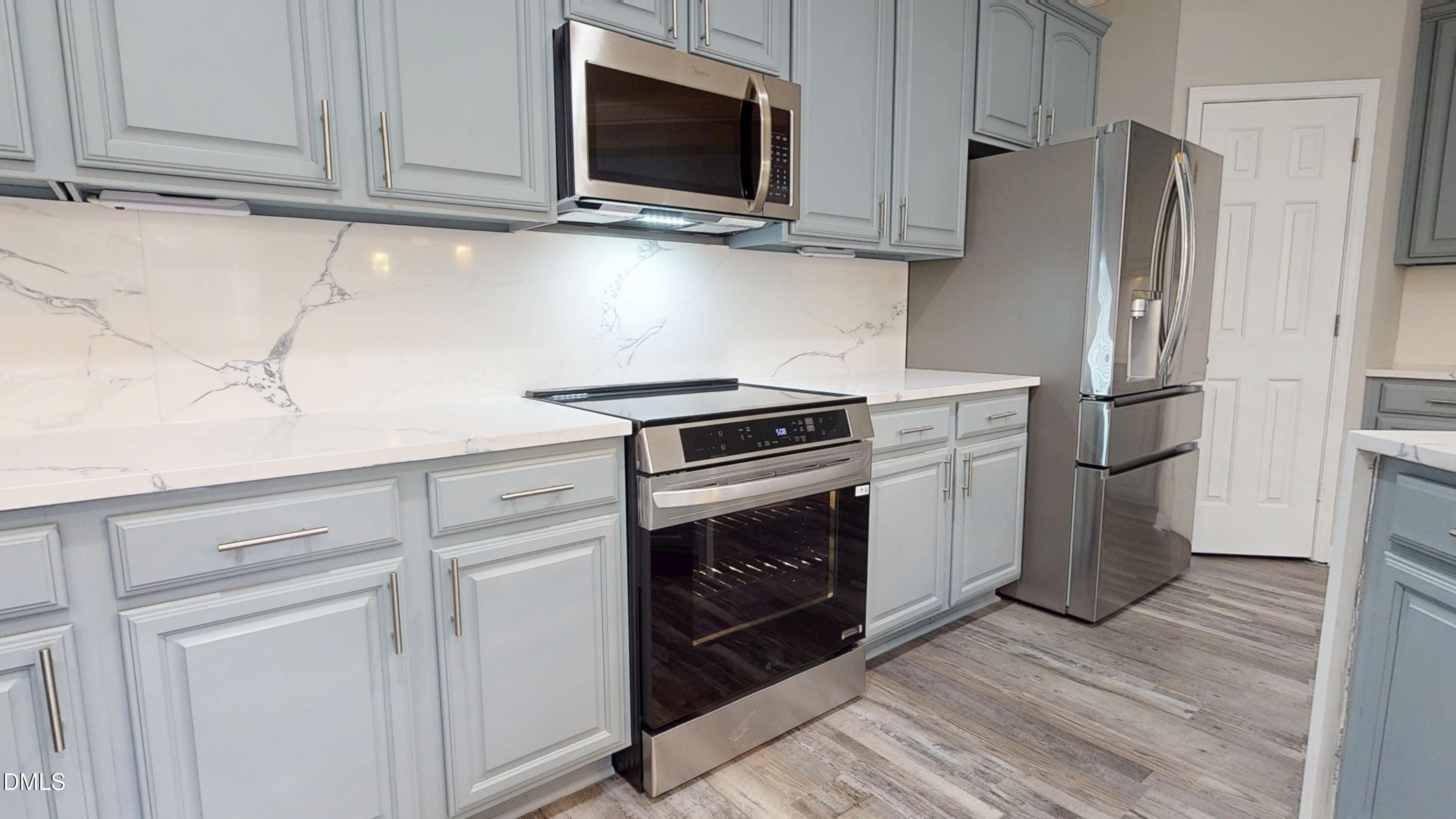 5708 Sea Fox Court Raleigh, NC 27616 - Photo 17 of 50 a kitchen with stainless steel appliances white cabinets and a stove