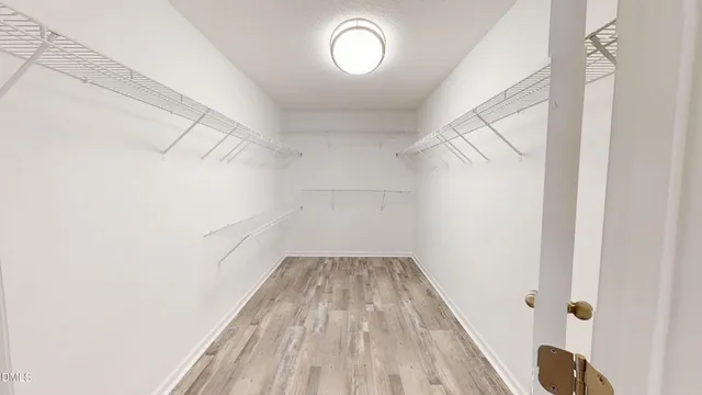 an empty room with wooden floor and a ceiling fan
