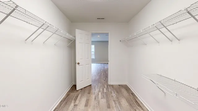 a view of a room with wooden floor and white walls