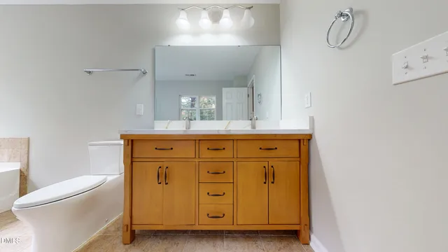 a bathroom with a granite countertop sink a toilet and shower