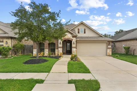 a front view of a house with a yard and trees