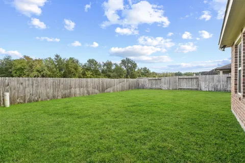 a view of a yard with an tree and wooden fence