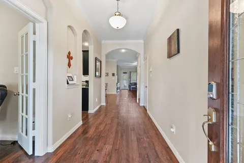 a view of a hallway with wooden floor and staircase