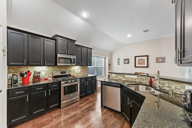 a kitchen with stainless steel appliances granite countertop a stove top oven and sink