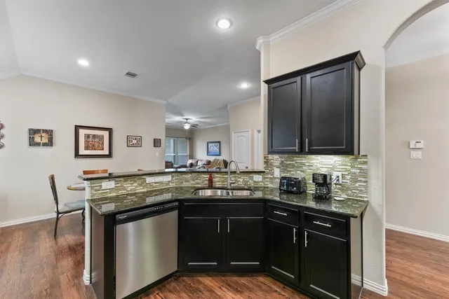 a kitchen with granite countertop a sink and cabinets