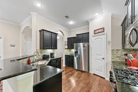a kitchen with stainless steel appliances granite countertop a sink stove and refrigerator
