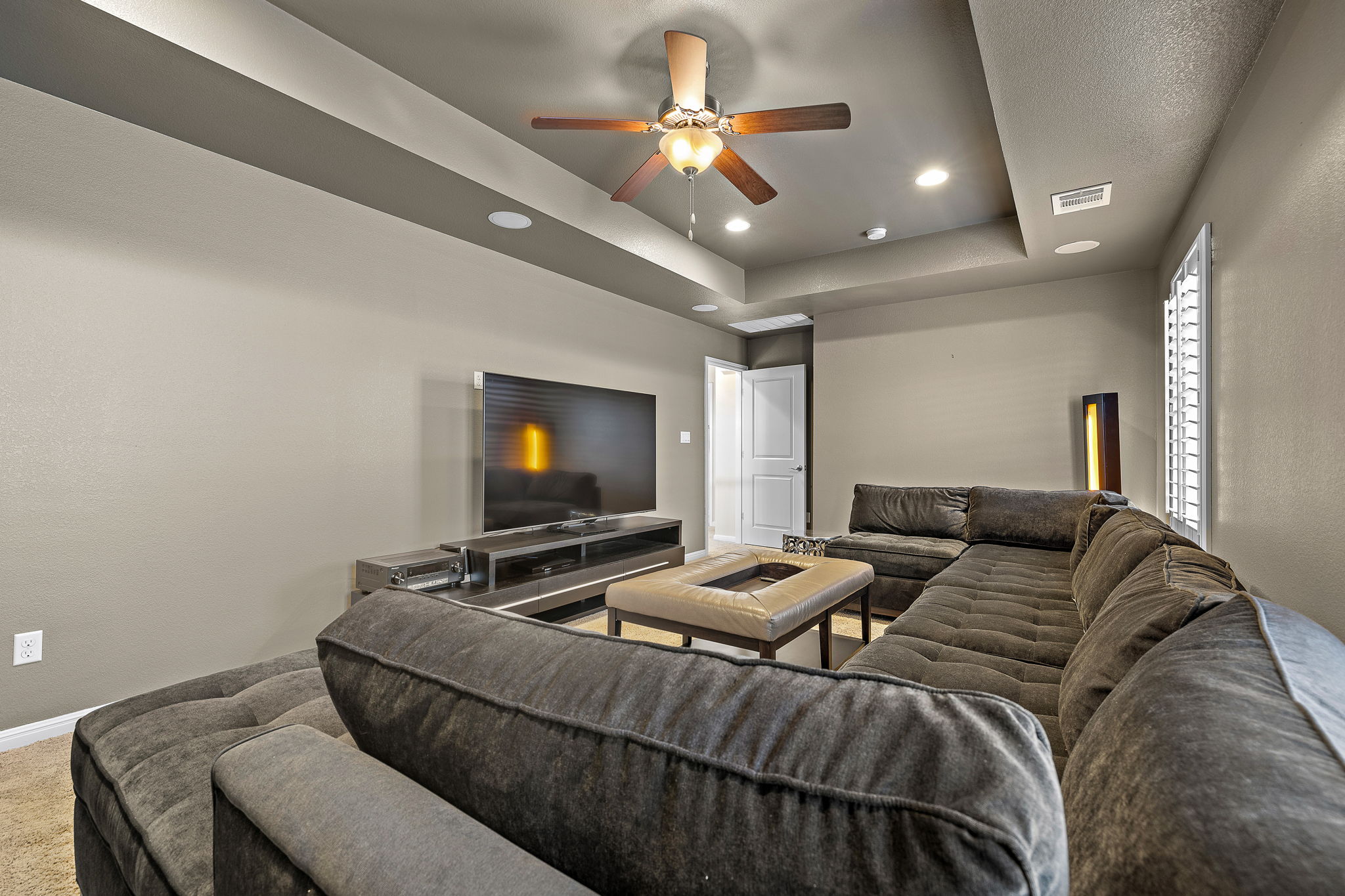 4413 Tambre Bend Austin, TX 78738 - Photo 22 of 30 Carpeted living room with ceiling fan, recessed lighting, a raised ceiling, and a textured wall