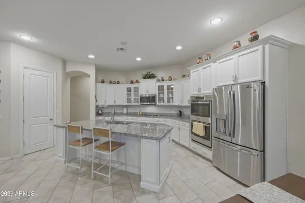 a kitchen with granite countertop a refrigerator and a stove top oven