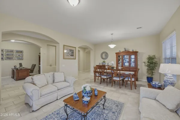 a living room with furniture a rug and a dining table