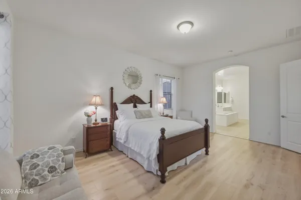 a large bed sitting in a bedroom and chandelier