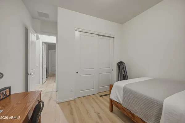 a bedroom with a bed and a flat tv screen on dresser