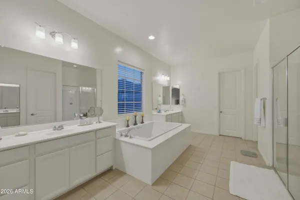 a spacious bathroom with a double vanity sink a mirror and a bathtub