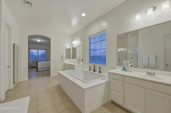 a spacious bathroom with a double vanity sink a mirror and a bathtub