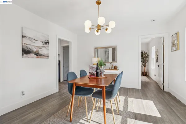 a view of a dining room with furniture a chandelier and wooden floor