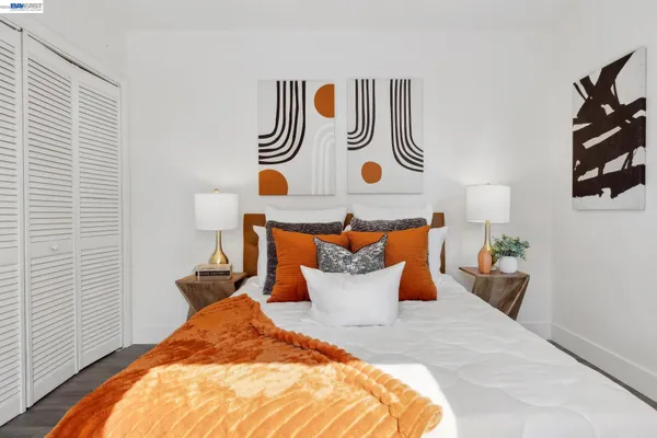 a bedroom with a bed and painting on the wall
